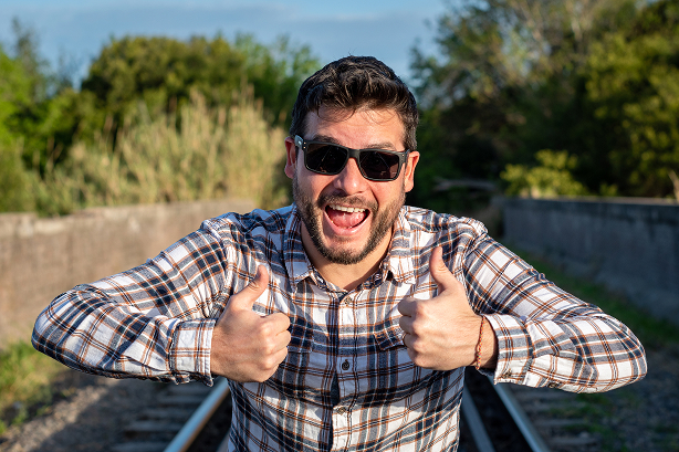 Excited patient giving a thumbs up while wearing sunglasses